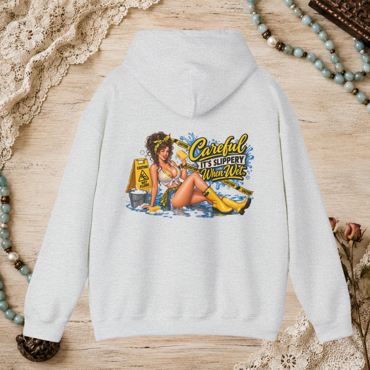 Back of a ash unisex hoodie featuring the Careful It’s Slippery When Wet vintage pin-up design