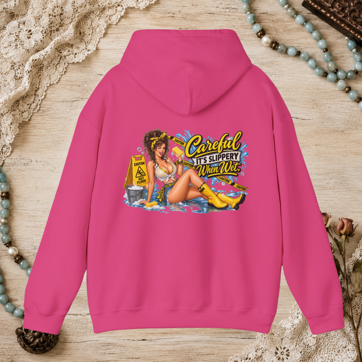 Back of a heliconia pink unisex hoodie featuring the Careful It’s Slippery When Wet vintage pin-up design