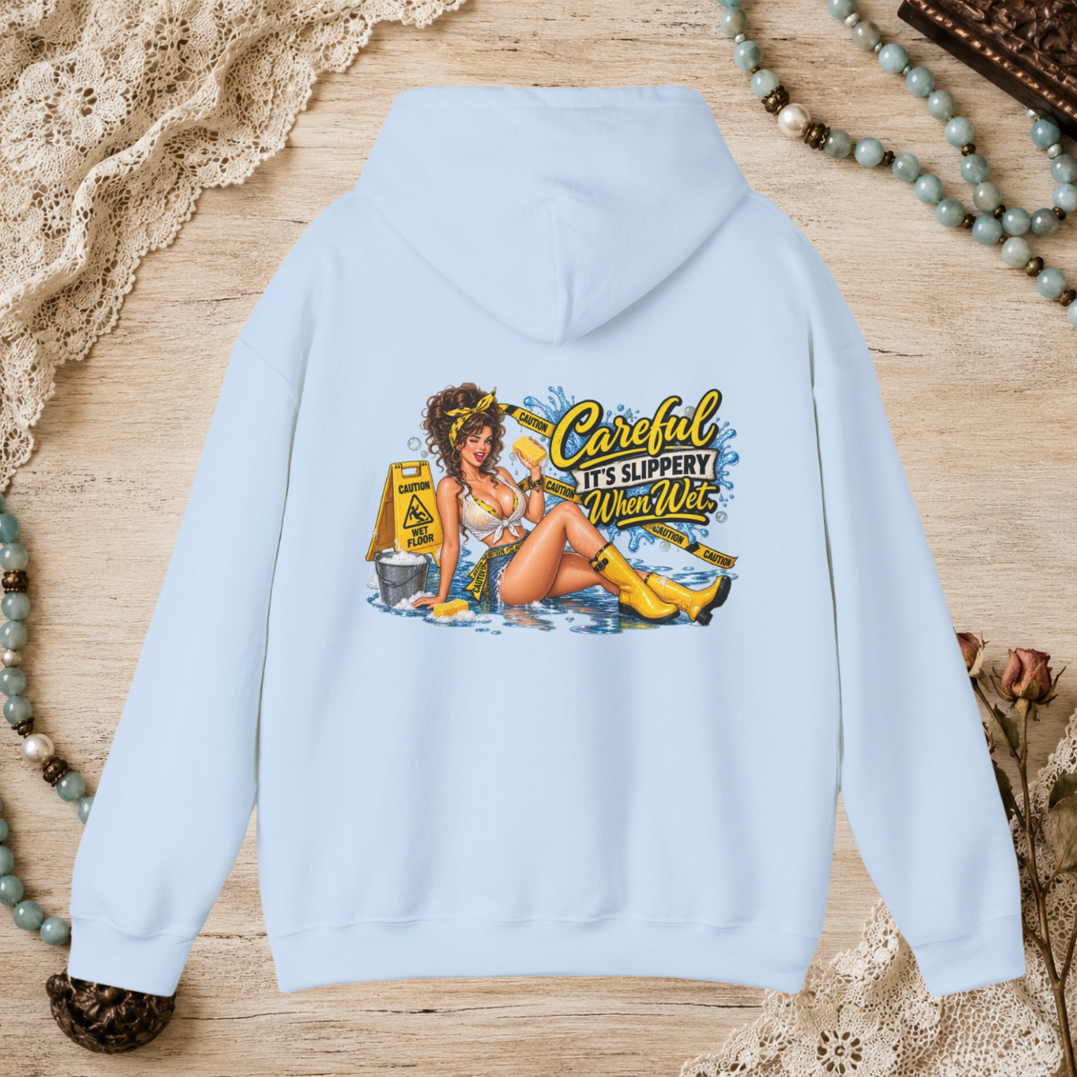 Back of a light blue unisex hoodie featuring the Careful It’s Slippery When Wet vintage pin-up design