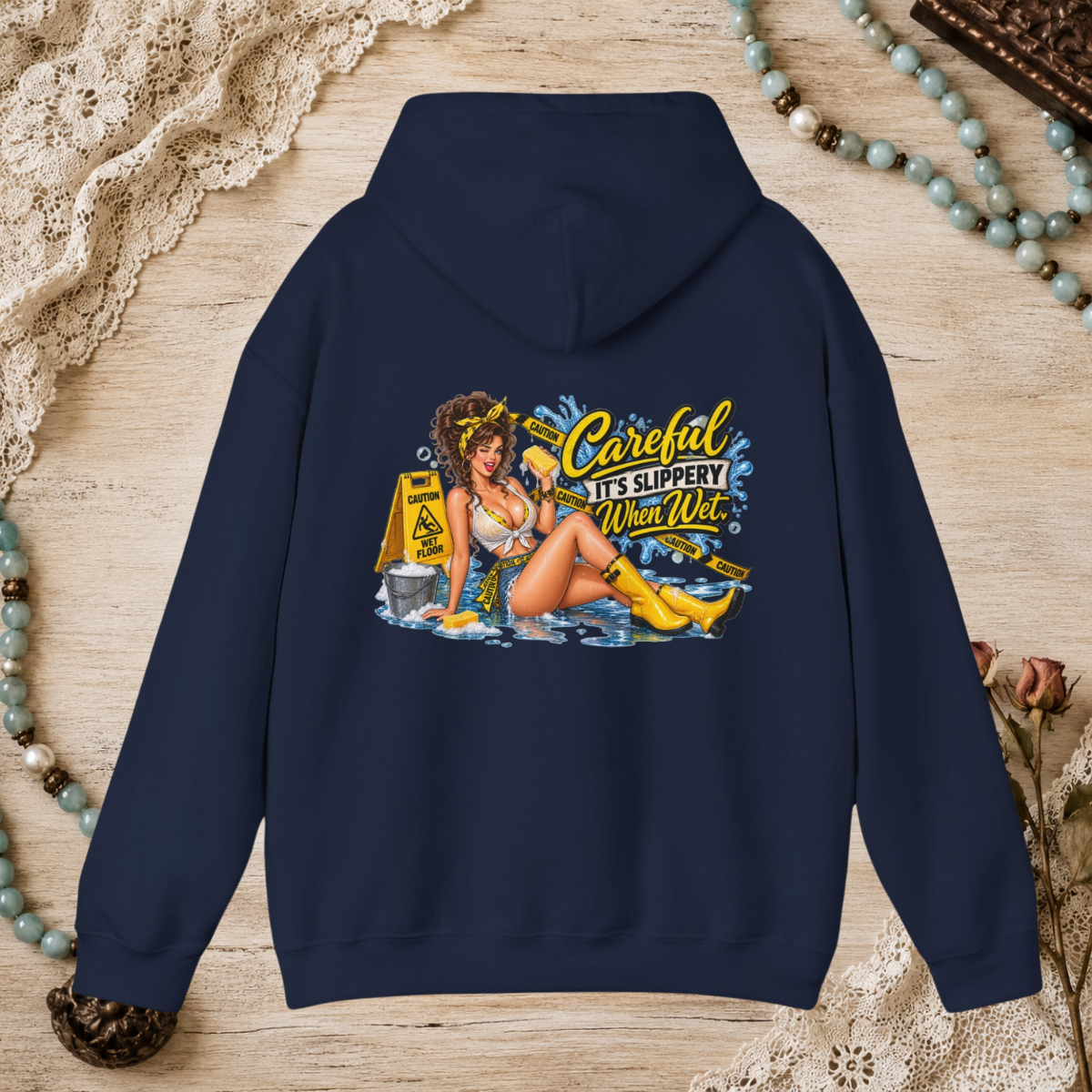 Back of a navy unisex hoodie featuring the Careful It’s Slippery When Wet vintage pin-up design