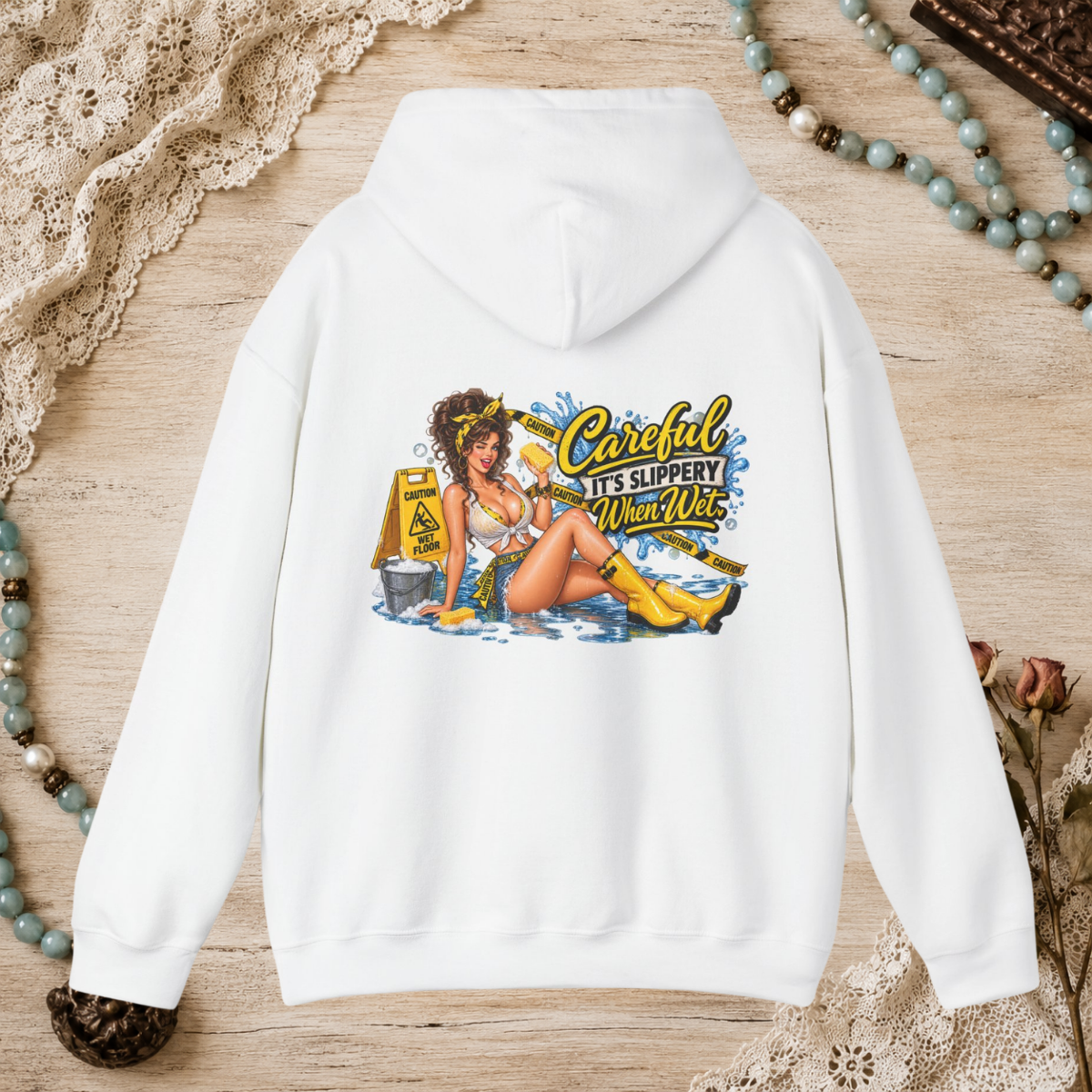 Back of a white unisex hoodie featuring the Careful It’s Slippery When Wet vintage pin-up design
