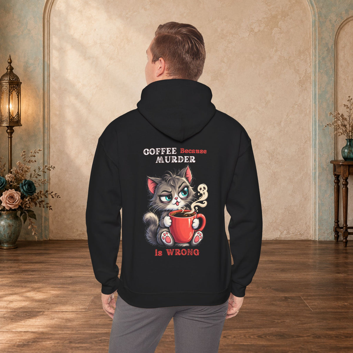 Male model wearing a black Coffee Because Murder Is Wrong hoodie with funny cat artwork on the back