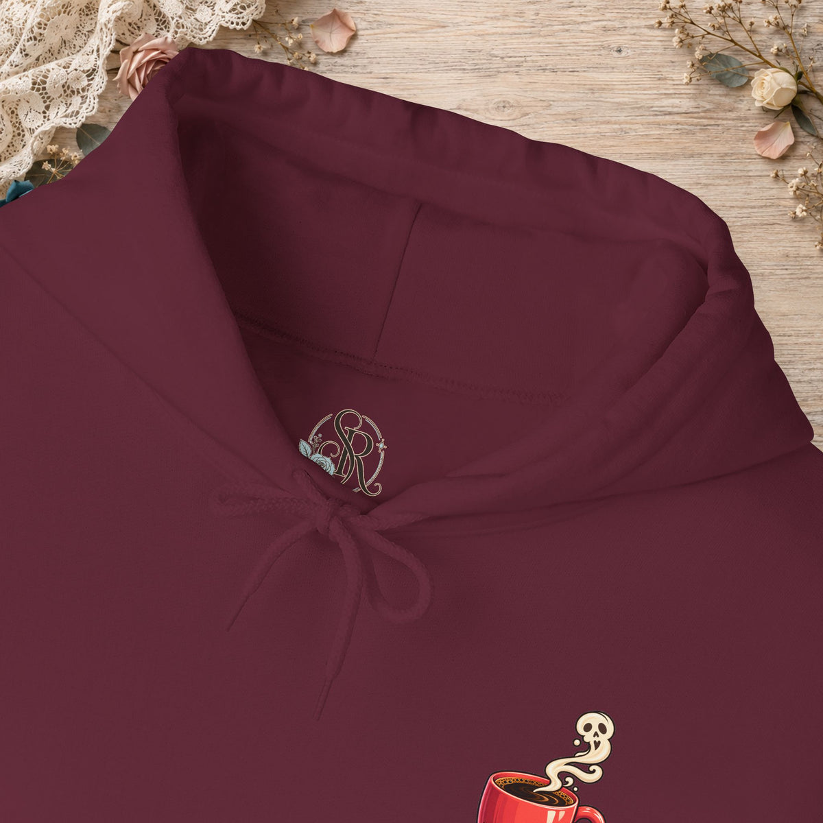 Close-up of the maroon hoodie neckline and small red coffee cup front design