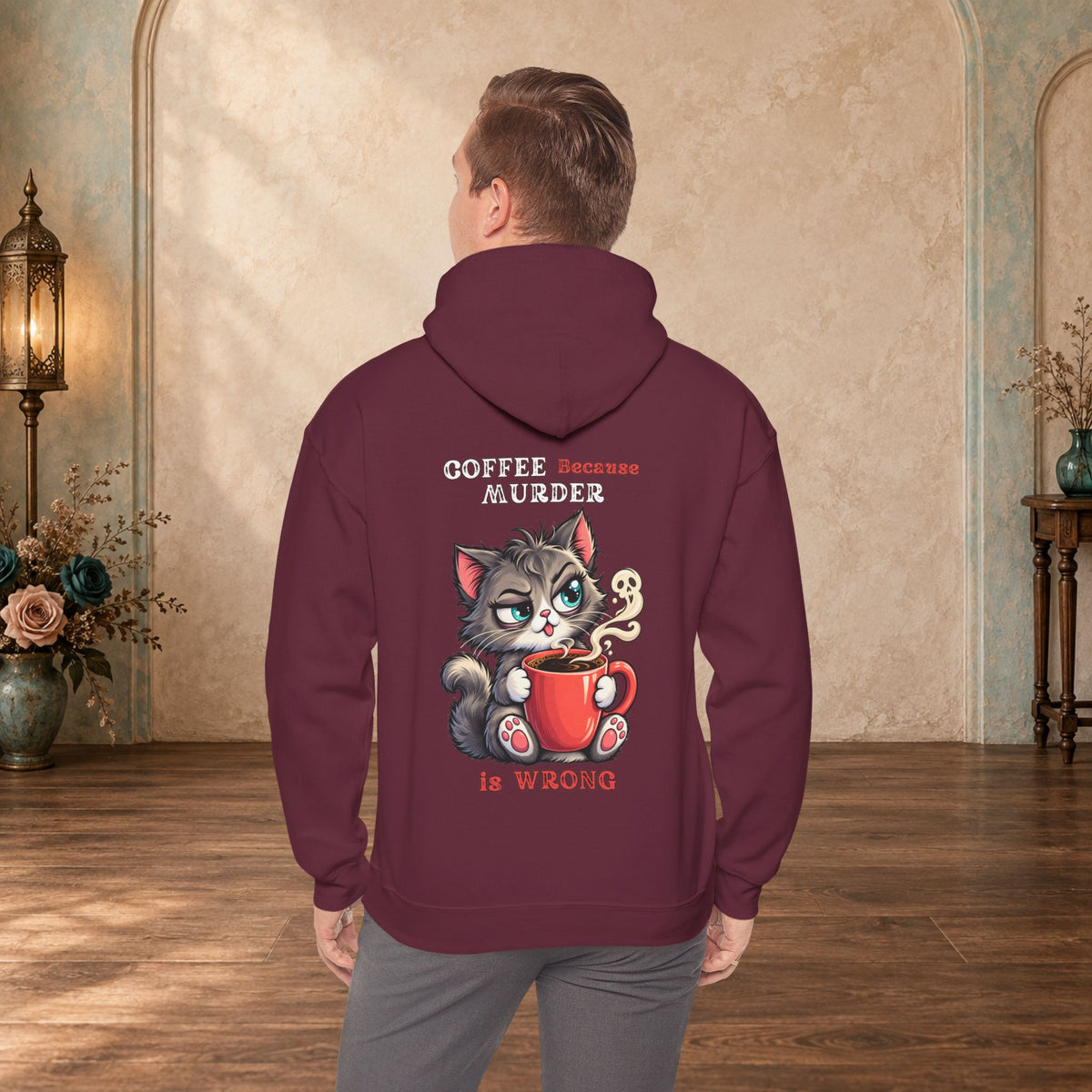 Male model wearing a maroon Coffee Because Murder Is Wrong hoodie with funny cat artwork on the back