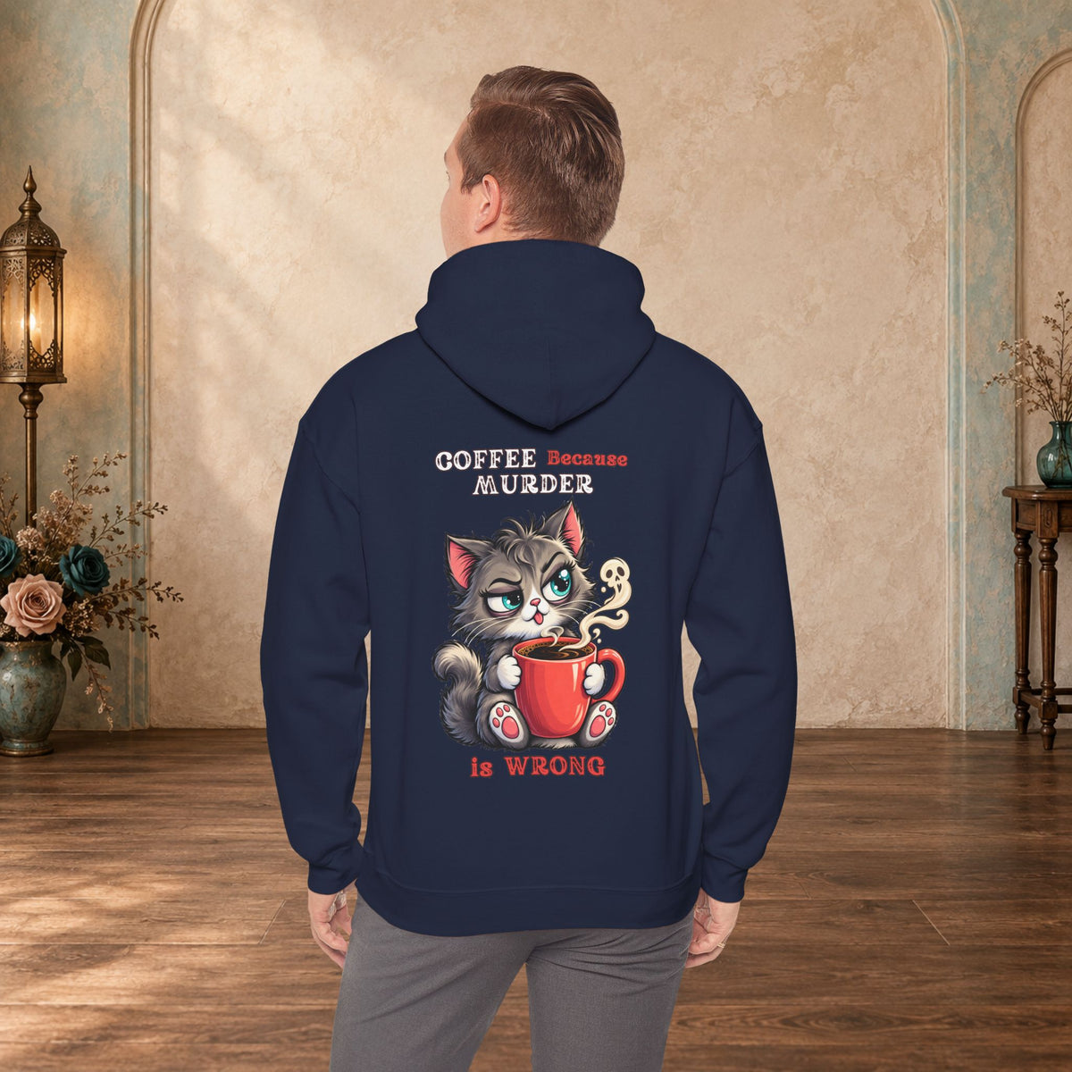 Male model wearing a navy Coffee Because Murder Is Wrong hoodie with funny cat artwork on the back