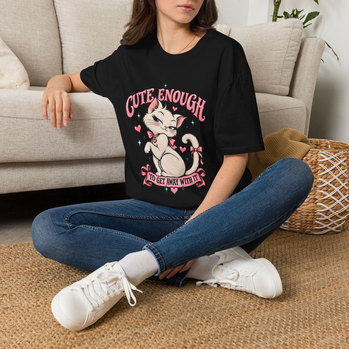 Woman seated on a sofa wearing a Black Cute Enough to Get Away With It unisex graphic T-shirt