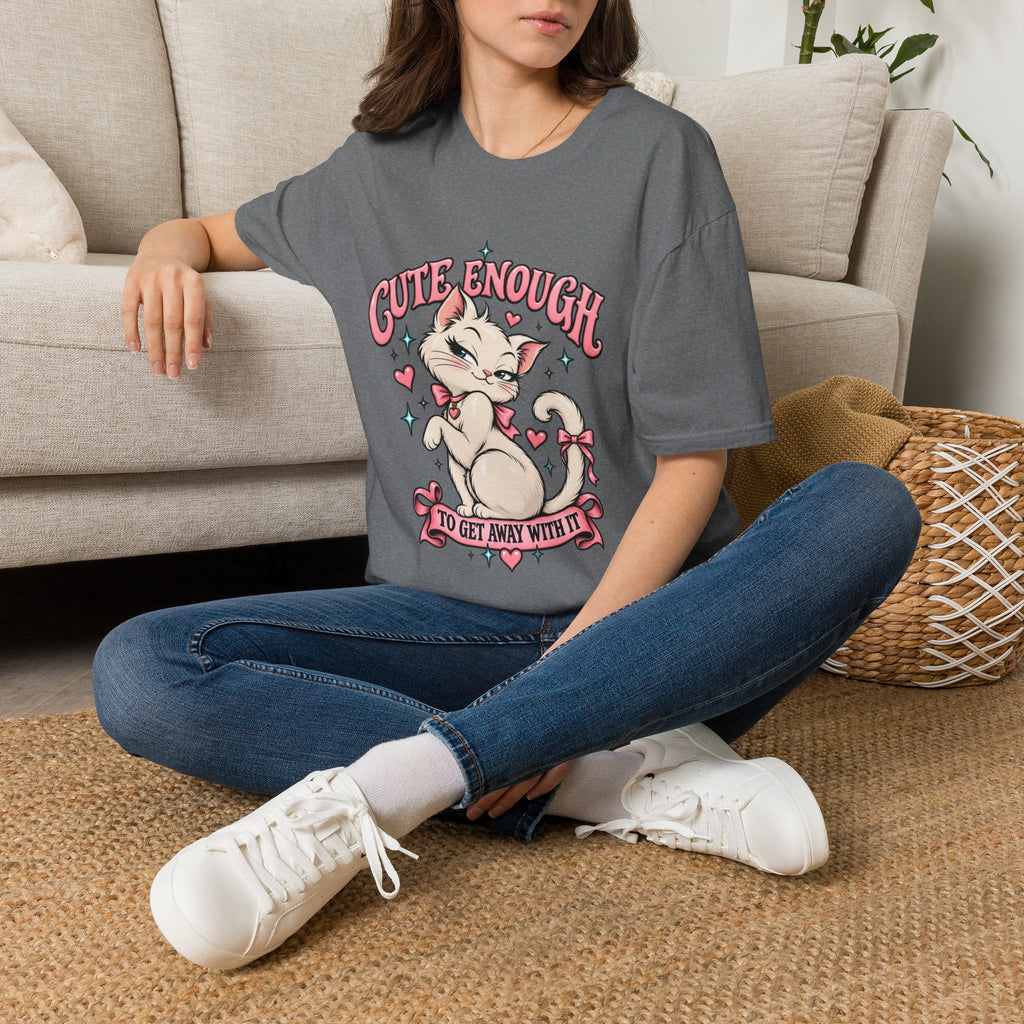 Woman seated on a sofa wearing a Graphite Heather Cute Enough to Get Away With It unisex graphic T-shirt