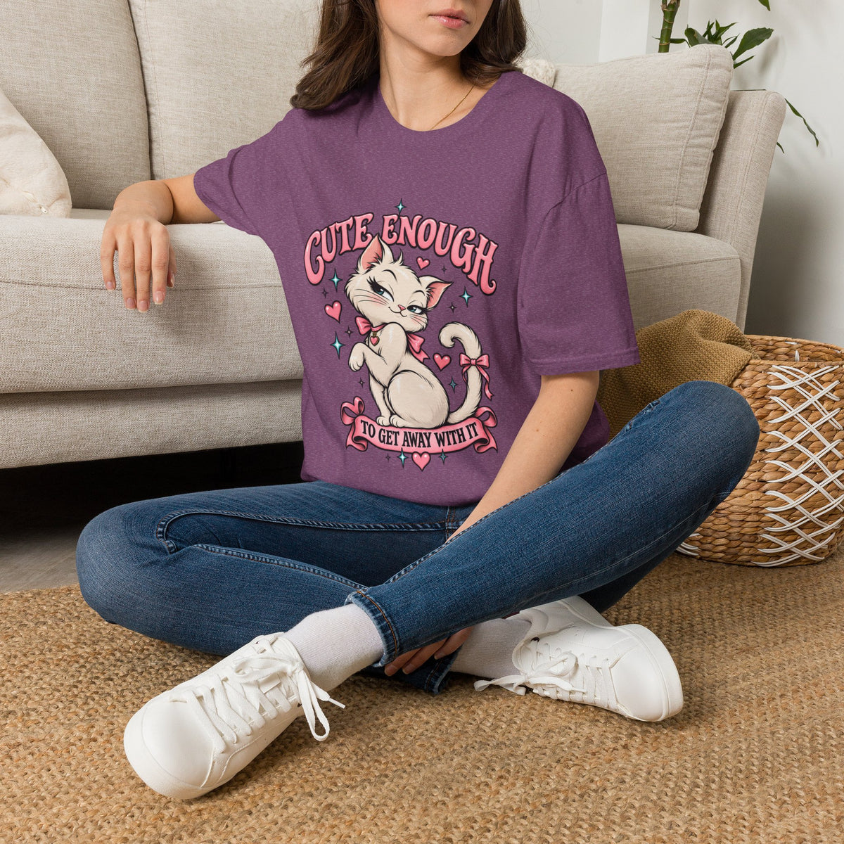 Woman seated on a sofa wearing a Heather Maroon Cute Enough to Get Away With It unisex graphic T-shirt
