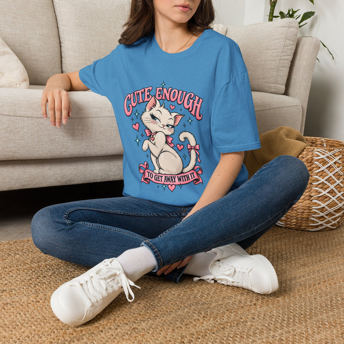 Woman seated on a sofa wearing a Heather Sapphire Cute Enough to Get Away With It unisex graphic T-shirt