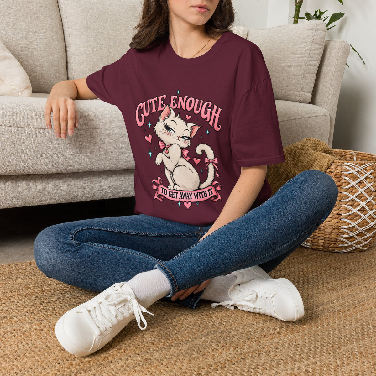Woman seated on a sofa wearing a Maroon Cute Enough to Get Away With It unisex graphic T-shirt