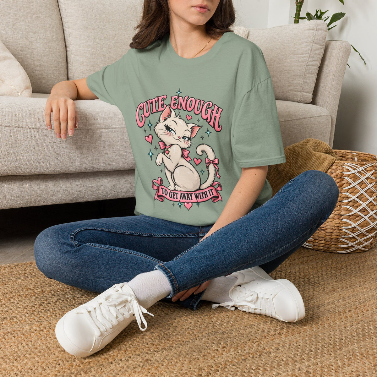 Woman seated on a sofa wearing a Sage Cute Enough to Get Away With It unisex graphic T-shirt