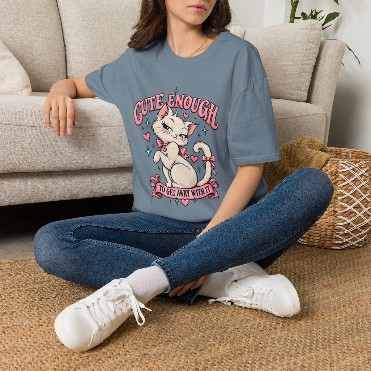 Woman seated on a sofa wearing a Stone Blue Cute Enough to Get Away With It unisex graphic T-shirt