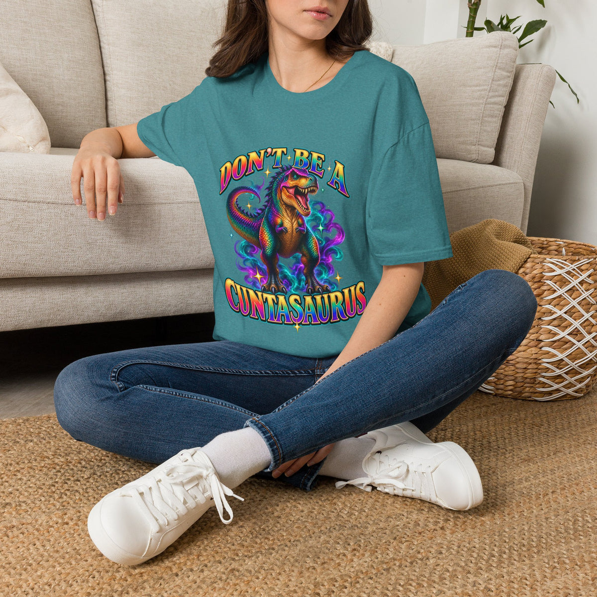 Woman wearing a heather Galapagos blue Don’t Be a Cuntasaurus dinosaur T-shirt