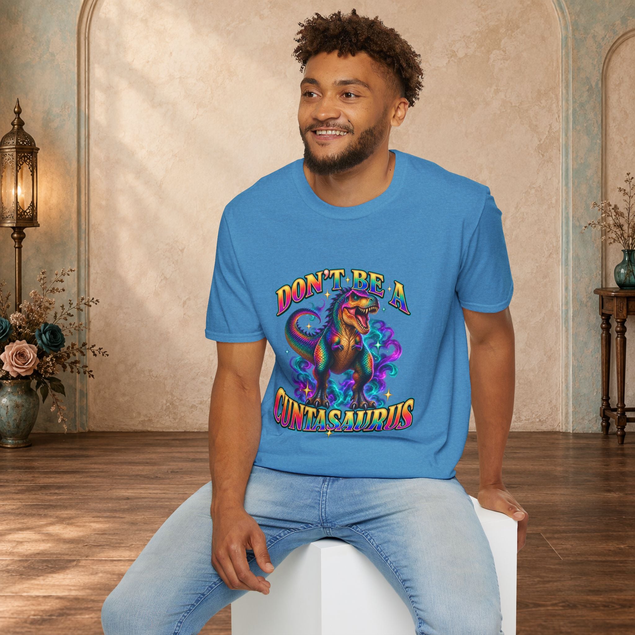 Man wearing a heather sapphire Don’t Be a Cuntasaurus colorful dinosaur T-shirt
