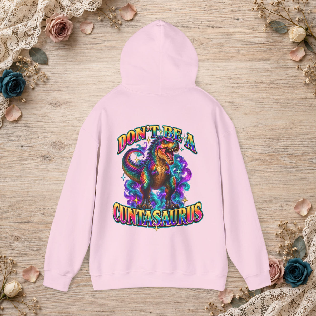 Light pink Don’t Be a Cuntasaurus hoodie featuring a rainbow T. rex back graphic