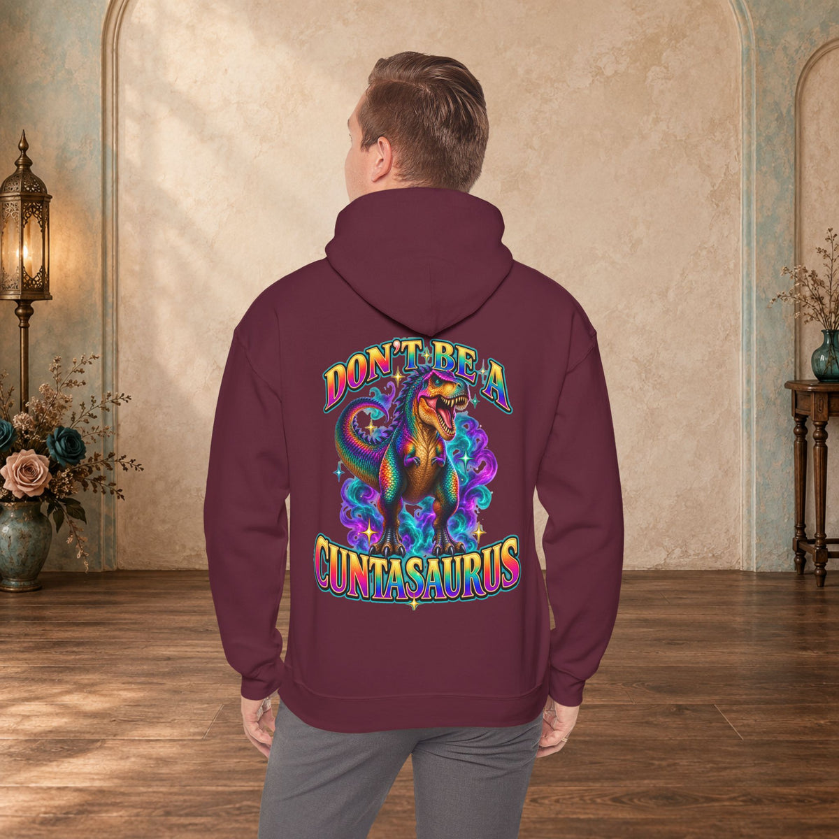 Man wearing a maroon Don’t Be a Cuntasaurus funny dinosaur sweatshirt shown from the back