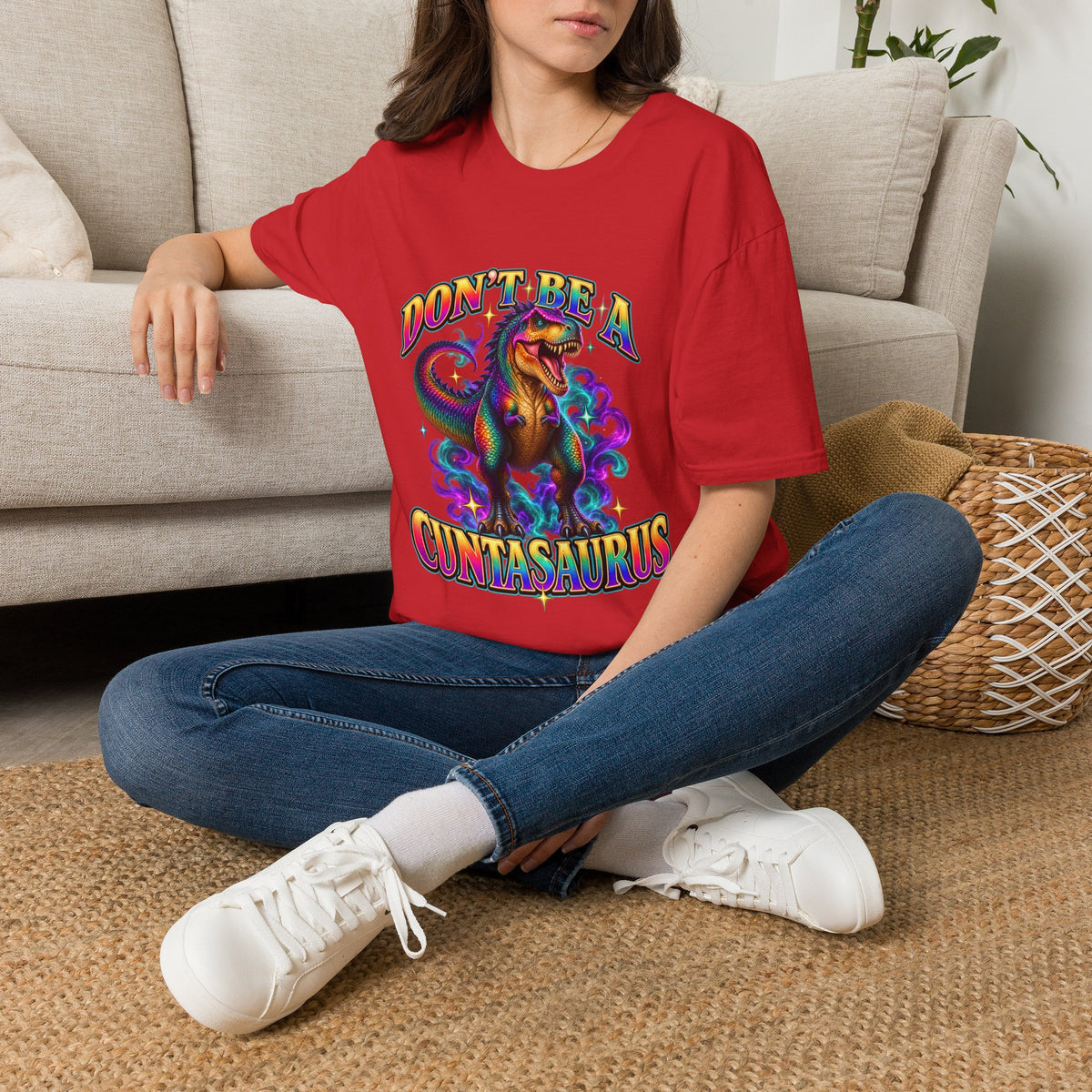 Woman wearing a red Don’t Be a Cuntasaurus colorful dinosaur graphic tee