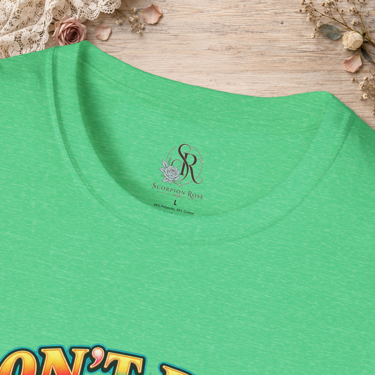 Close-up of the collar and colorful print on the Don’t Be a Cuntasaurus T-shirt