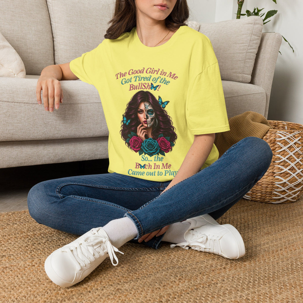 Seated woman wearing a Cornsilk Good Girl in Me sugar-skull T-shirt