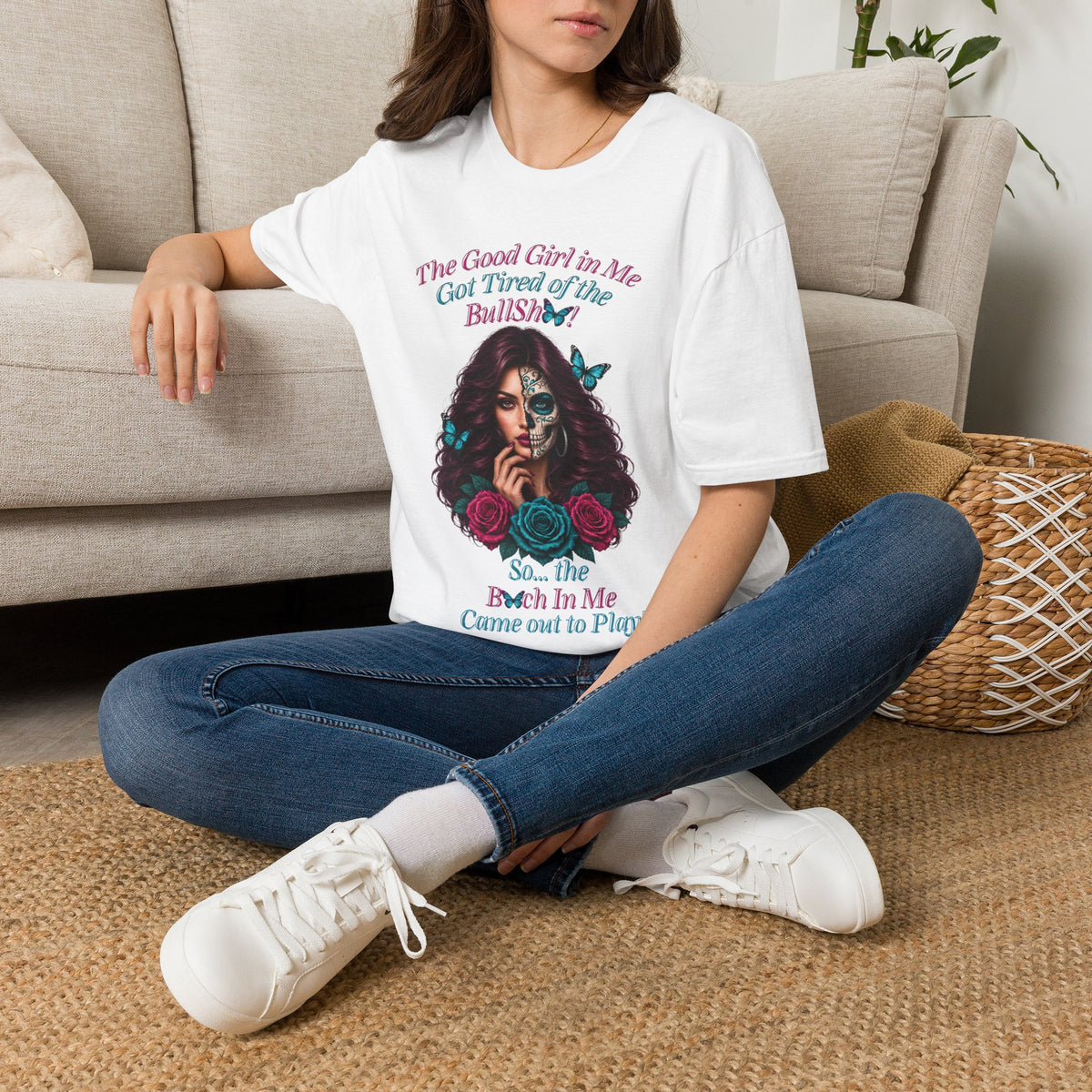 Seated woman wearing a White Good Girl in Me sugar-skull T-shirt
