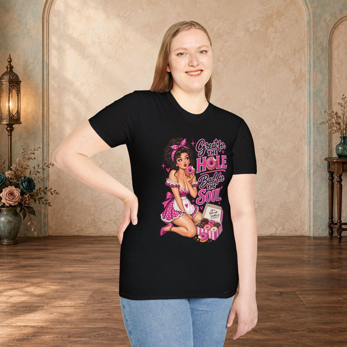 Woman modeling a black unisex T-shirt featuring the Great for the Hole, Bad for the Soul pink pin-up design.