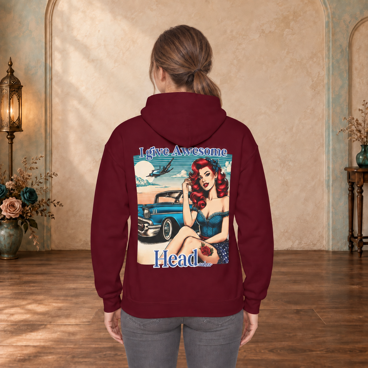 Female model wearing a Maroon I Give Awesome Headaches hoodie featuring retro pin-up artwork on the back