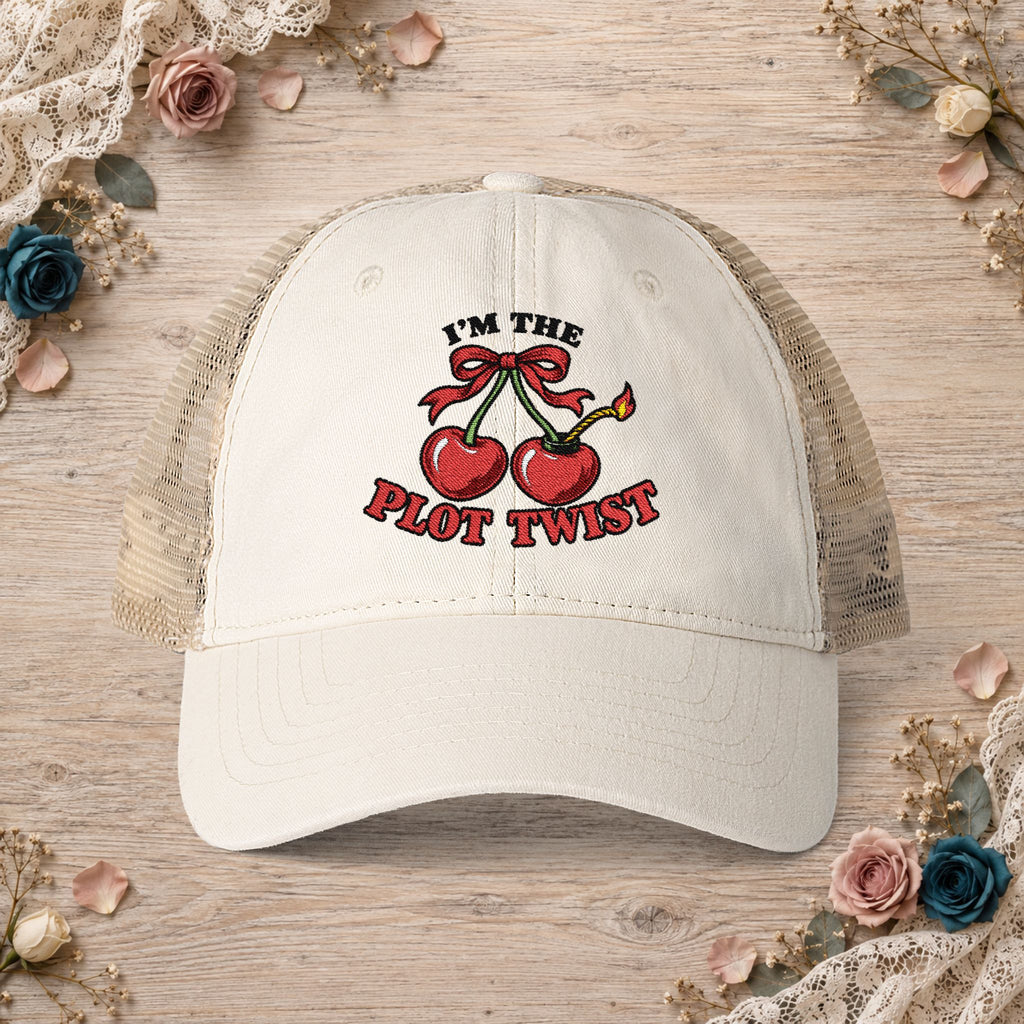 Vanilla women’s mesh-back hat with an embroidered I’m the Plot Twist cherry bomb design.