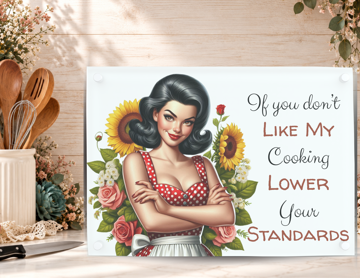 Lower Your Standards tempered glass cutting board displayed with a kitchen knife, utensils, and floral accents