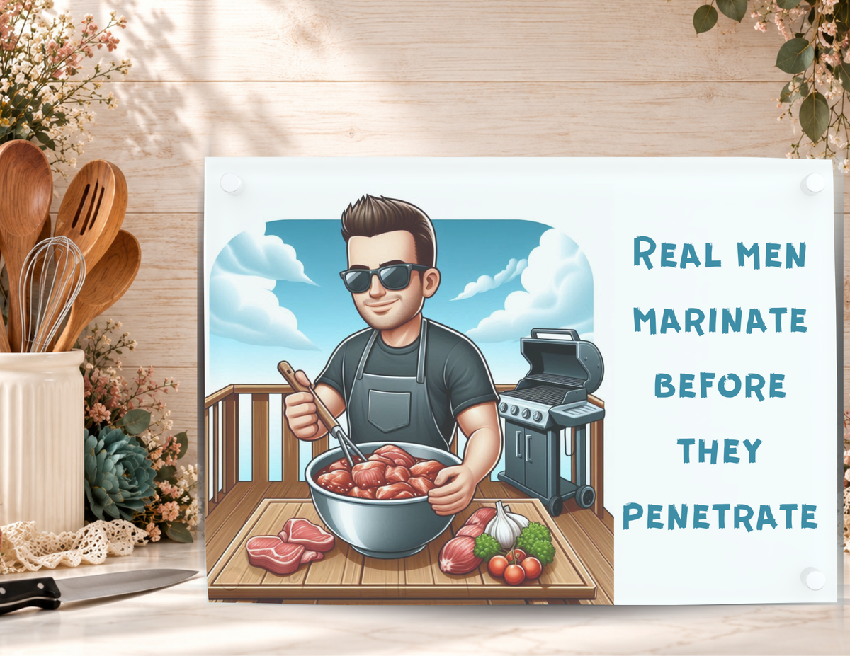Real Men Marinate Before They Penetrate tempered glass cutting board displayed with a kitchen knife, utensils, and floral accents