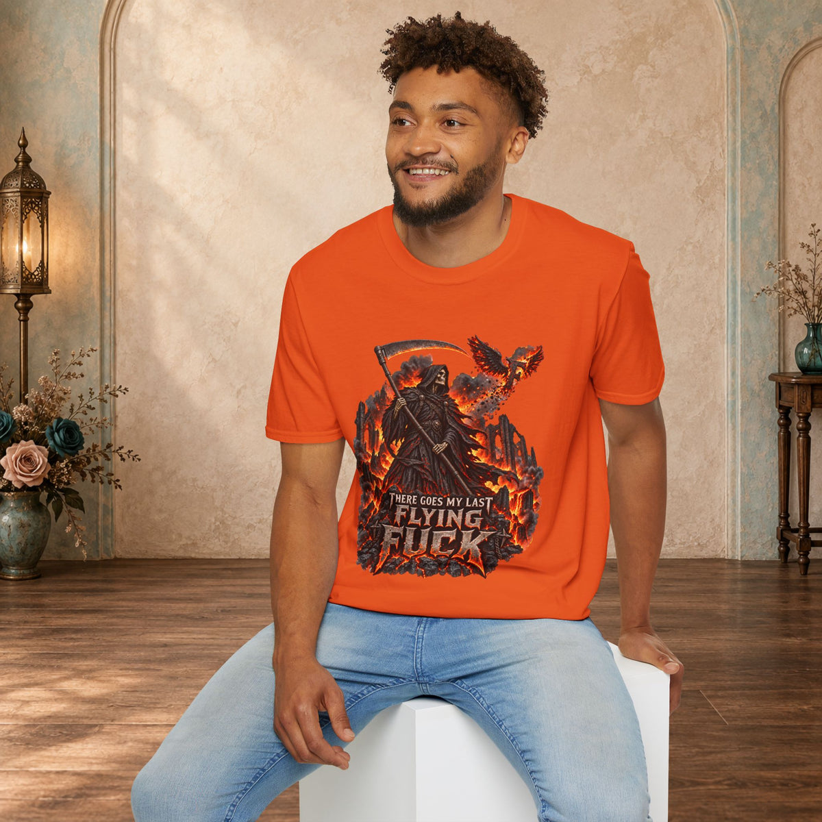 Seated man wearing an Orange There Goes My Last Flying Fuck Grim Reaper graphic T-shirt